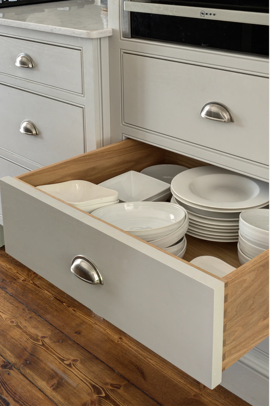 Solid timber drawer with fitted storage for plates and bowls