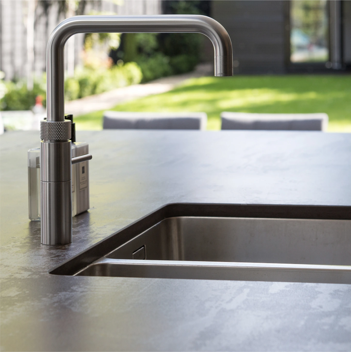 Contemporary brushed metal tap overlooking the garden