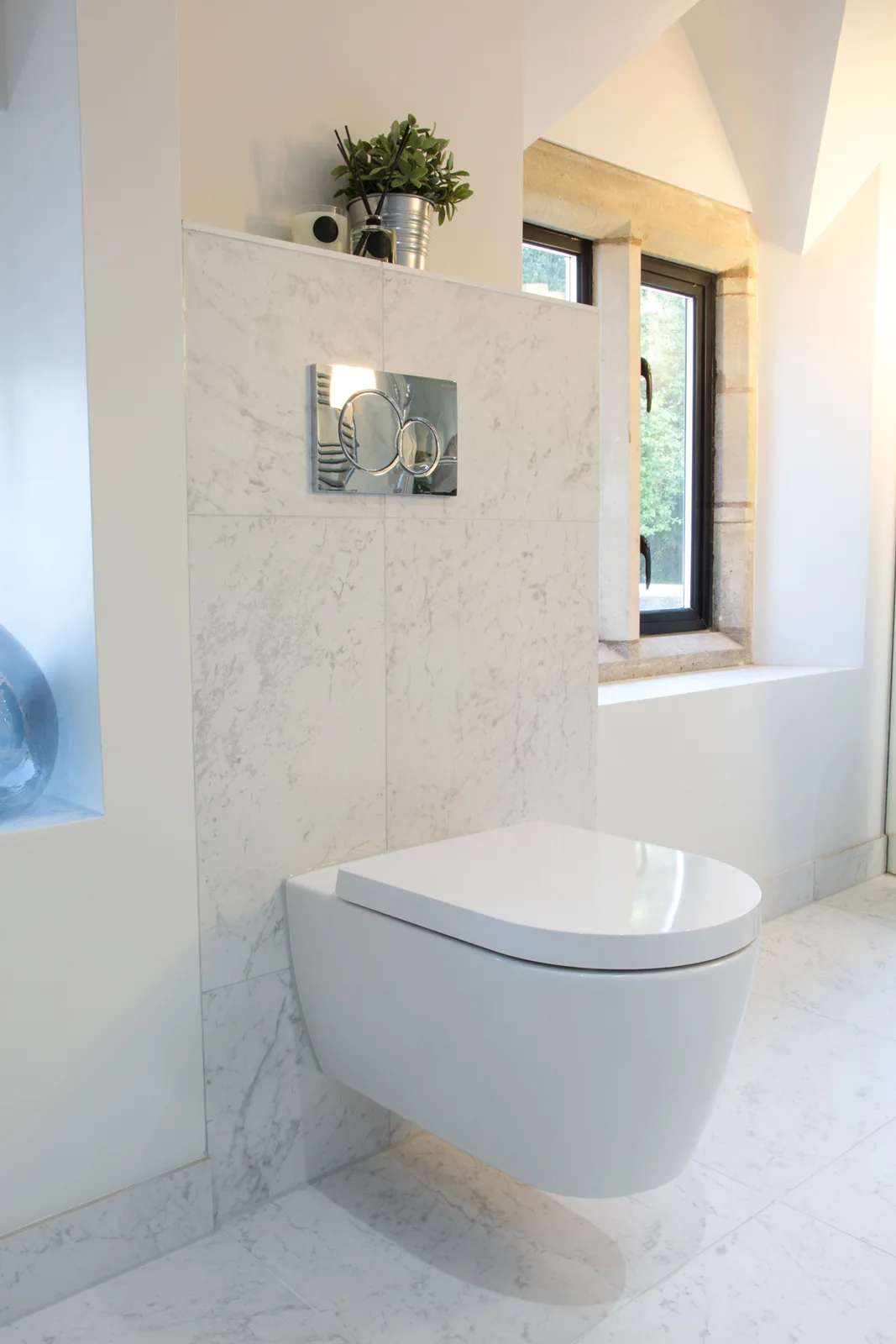 Wall-hung toilet beside a deep window recess in the en-suite
