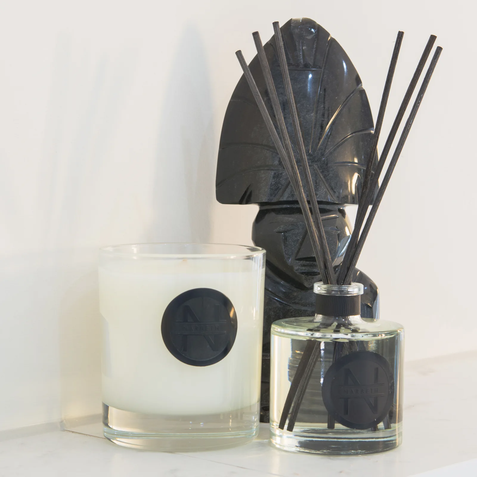 Soap dispenser and diffuser on a marble-look bathroom surface